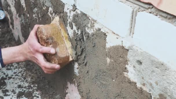 Mans hand pleisterwerk een muur isolatie en huis stichting met troffel. Doe het zelf. — Stockvideo