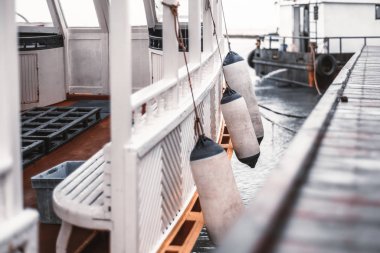 Nakliye birden çok arabellek dalgıçlar için kullanarak boş bir ahşap tekne yan görünüm üstünde belgili tanımlık etraf dubalar; deniz gemi içinde hiç kimse ile balıkçılık için yağmurlu bir günde iskeleye demirlemiş