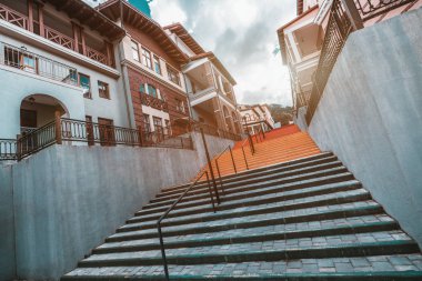 Dağlar mesafe uzun renkli merdiven kentsel ayarlarında; ufuk noktası ile bolluk-in temiz ve modern Avrupa evleri iki tarafta içine uzanan güzel merdiven