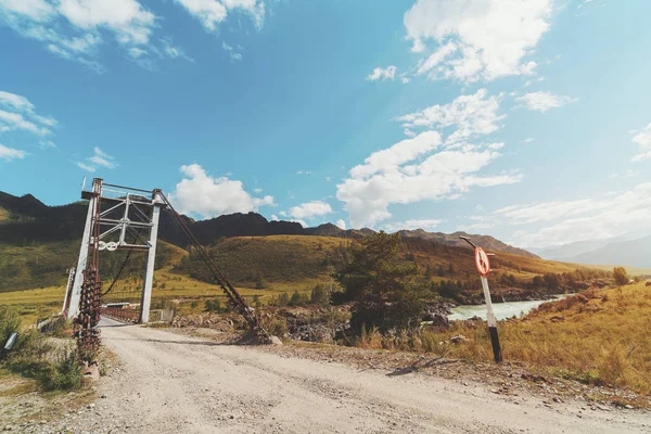 ロープの広角視界橋道路標識と背景 晴れた夏の日 アルタイ山脈 Kuyus ロシアに前景色と丘の尾根に未舗装の道路山川 — ストック写真