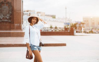 Şapkalı göz kamaştırıcı Afrikalı-Amerikalı kız açık havada vintage film kamera ile gülümseyerek; neşeli sevimli genç siyah erkek retro cam ile sokakta kopyalama alanı alanı sağdaki, Moskova, Rusya ile