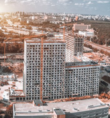 Yukarıdan damperli kamyonlar, ekskavatör, Vinçler gibi inşaat malzemeleri bol olan bir büyük, yüksek katlı konut veya office ev bina sitenin görüntülemek; yapım aşamasında
