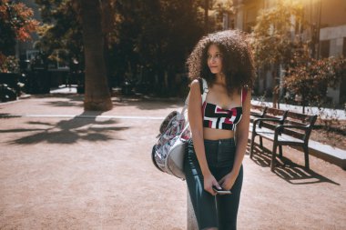 Kıvırcık afro saçlı Sevimli ürkek beyaz kız sokakta karşı direğe yaslanmış ve bir kenara reklam metin veya logo, Barcelona, İspanya için kopya alanı yer ile seyir duruyor