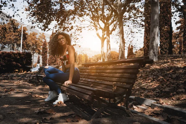 Affascinante Hipster Donna Riccia Occhiali Seduto Sulla Panchina Del Parco — Foto Stock