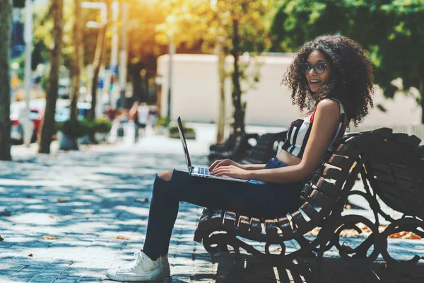 Uma Menina Hipster Bonito Rindo Está Sentado Banco Parque Trabalhando — Fotografia de Stock