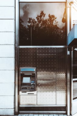 Frontal dikey görünüm sokak Bankamatik Atm ile boş bir ekran ve bir metal kalıp çevresinde; açık bir otomatik vezne makinesi