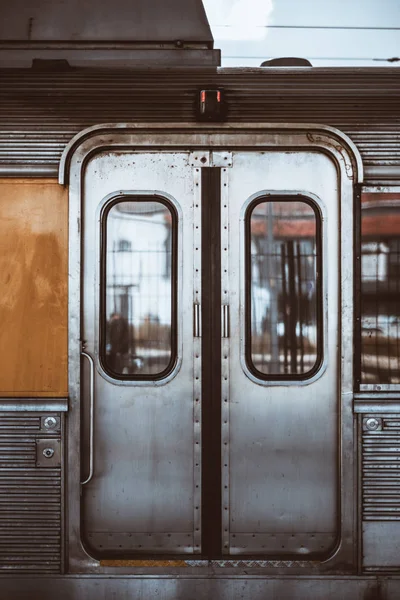 一个欧洲郊区火车的镀铬车厢装饰的金属粗糙的自动门的垂直镜头 有窗户 两个开口按钮 手拿和下面的圆形锁 — 图库照片