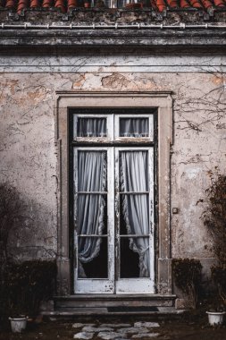 Kısmen kuşbaşı sıva duvarla çevrili bir antika sundurma bir peeling ahşap boyama çerçeve ve içinde eski beyaz dantel perdeler ile dikey çekim; tipik mimari Sintra, Portekiz