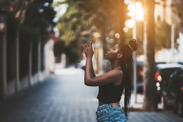 Charming African Teen Braided Hair Using Camera Her Smartphone Photoshoot — Stock Photo, Image