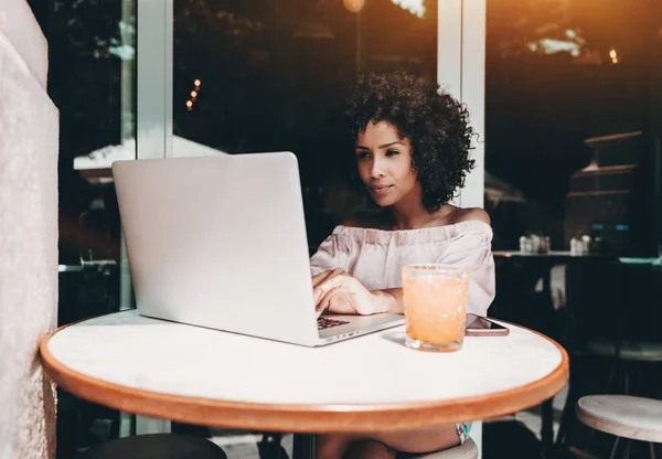 Biracial chica en un bar con portátil — Foto de Stock