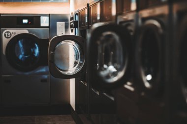 Dark laundry room with empty washers clipart