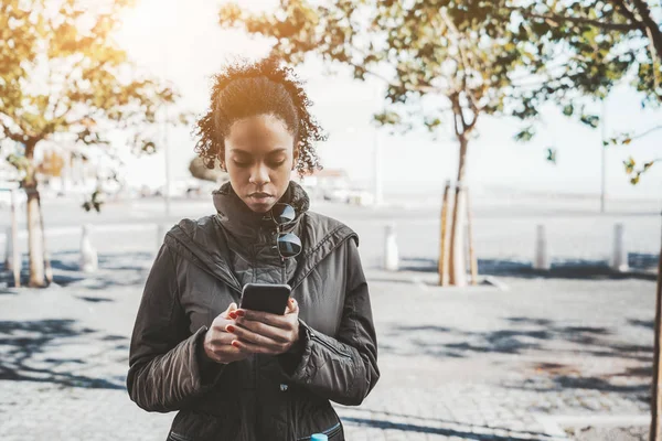 Mixed girl with a cellphone outdoors — Stock Photo, Image