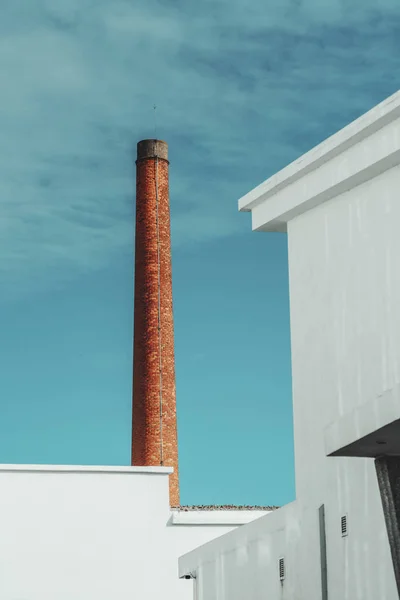 Red smoke pipe behind building walls — Stock Photo, Image