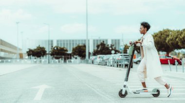 E- scooter kullanan siyah bir kız.