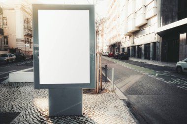 Kentsel ortamlarda boş bir reklam panosunun maketi; kaldırımın kaldırım taşı üzerinde boş bir dikey sokak afişi; tek şeritli yol modelinin yanında bir açık hava poster tutucu modeli