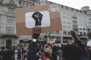 Porto, Portekiz - 6 Haziran 2020: ırksal ayrımcılığa karşı gösteri, siyahların yaşamları önemlidir; elinde yumruk işareti olan Afrikalı bir adamın arkasından bakın.