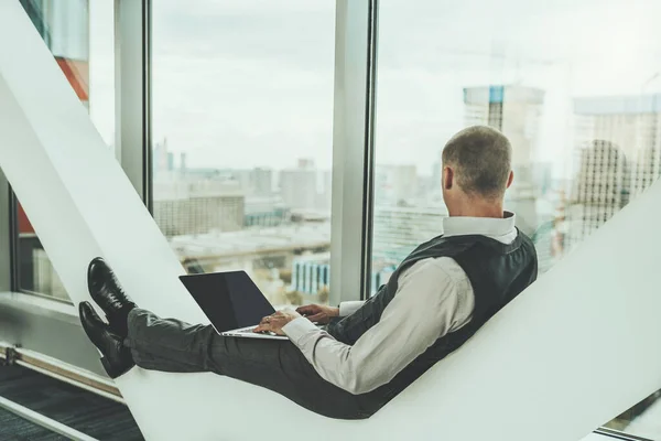 Силуэт Мужчины Предпринимателя Отдыхающего Современной Офисной Скамейке Ноутбуком Руках Задумчиво — стоковое фото