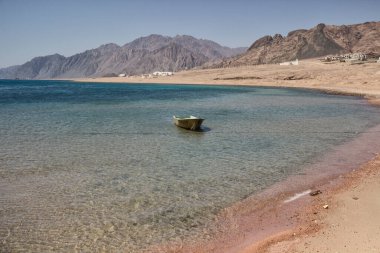Deniz kıyısında eski bir tekne, güneşli bir gün.