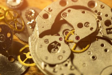 Saatçi atölyesindeki mekanik saatleri tamir ediyor.