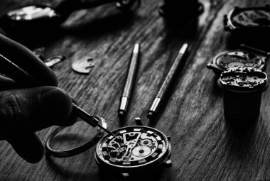 Bir saatçi antika bir otomatik saati tamir ediyor..