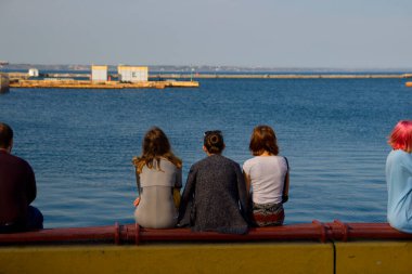 İnsanlar deniz kıyısında dinleniyor.