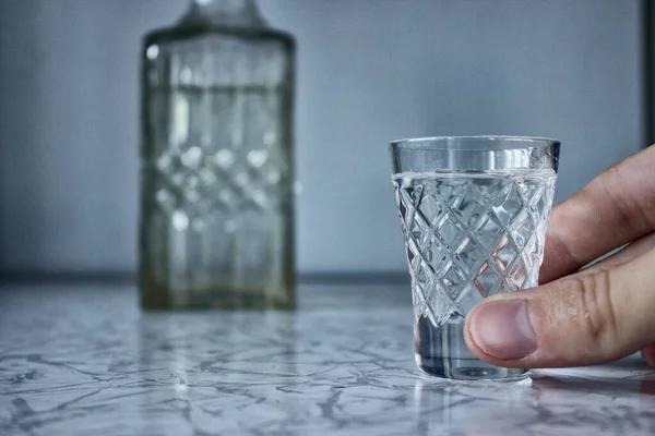 Alkolizm, kolunda votka bardağı var.