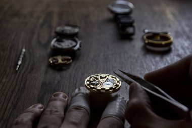 Saatçi eski bir vekanik saati tamir ediyor.