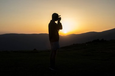 Atlılarla fotoğraf çeken bir adamın silueti.
