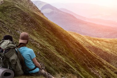 Bir adam dağ manzarasından, turizmden zevk alır.
