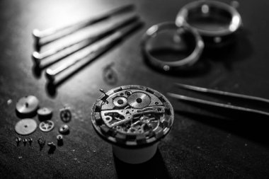 Saatçi antika bir otomatik saati tamir ediyor..