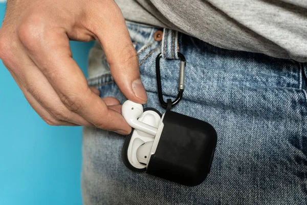 Adam kablosuz bir kulaklığı bir davadan alıp kapatıyor.