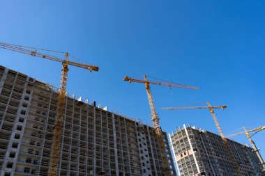 Ev yapımı, inşaat vinçleri, bitmemiş ev güneşli bir gün.