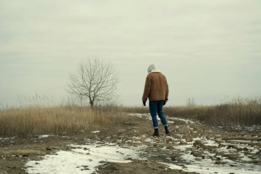 Bir adam tarlada kalır, bir adam, bir ağaç.