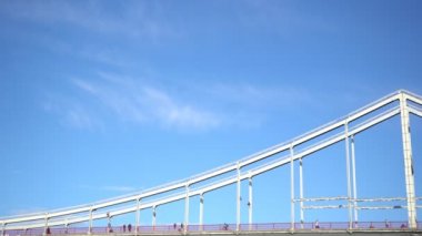 İnsanlar köprüde yürüyor ve bisiklete biniyor.