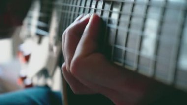 Erkek eli, gitar çalan bir adam.