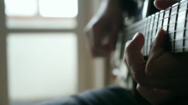 Erkek eli, gitar çalan bir adam.