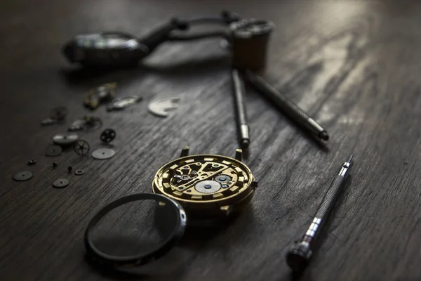 A watch maker is repairing a vintage automatic watch.