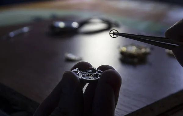 A watch maker is repairing a vintage automatic watch.