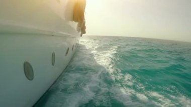 İnsanlar denizde lüks bir yatta eğleniyorlar.