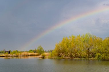 Bulutlu gökyüzünde gökkuşağı, manzara