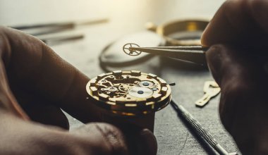 Saatçi mekanik kol saati takıyor.