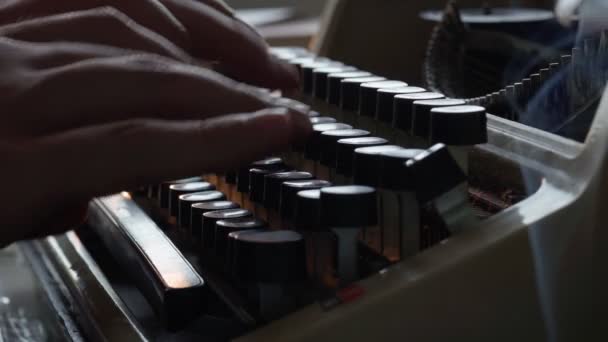 Facet pisze na starej maszynie do pisania i pali papierosy, pisarz, dziennikarz — Wideo stockowe