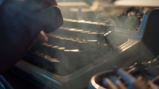 Facet pisze na starej maszynie do pisania i pali papierosy, pisarz, dziennikarz — Wideo stockowe
