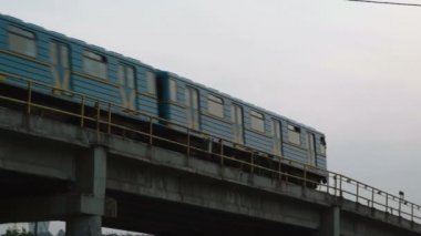 Gün batımında köprüden geçen Kyiv Metro Treni