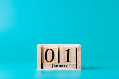 1 Ocak tarihli tahta blok takvimi turkuaz mavi arka plan, yatay çekim. Uzayı kopyala Yeni yıl kavramı, planlama ve kutlamalar