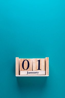 Ahşap takvim bloklarının dikey yakın plan çekimi ve mavi zemin üzerinde tarih 01 Ocak. Uzayı kopyala İlk gün, yeni yıl ve yeni zorluklar kavramı