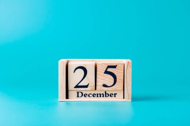 25 Aralık tarihli tahta blok takvimi turkuaz mavi arka plan, yatay çekim. Uzayı kopyala Noel, tatil ve gelenek kavramı