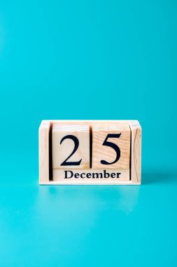 25 Aralık tarihli tahta blok takvimi turkuaz mavi arka plan, dikey çekim. Uzayı kopyala Noel, tatil ve kutlama kavramı