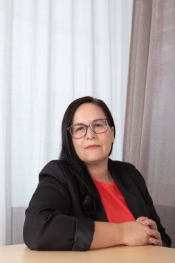 Profesyonel ortamda bir masada oturan olgun bir yöneticinin portresi, ciddi ve analitik davranışlar, iş ve koçluk için uygun. Çalışma konsantrasyonu kavramı