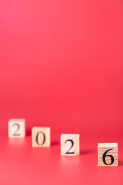 2026 numara, seçici odaklı, kırmızı arkaplan, dikey yönelimli, alçalan köşegen küpleri üzerine. Uzayı kopyala Zaman geçişi ve beklentiler kavramı